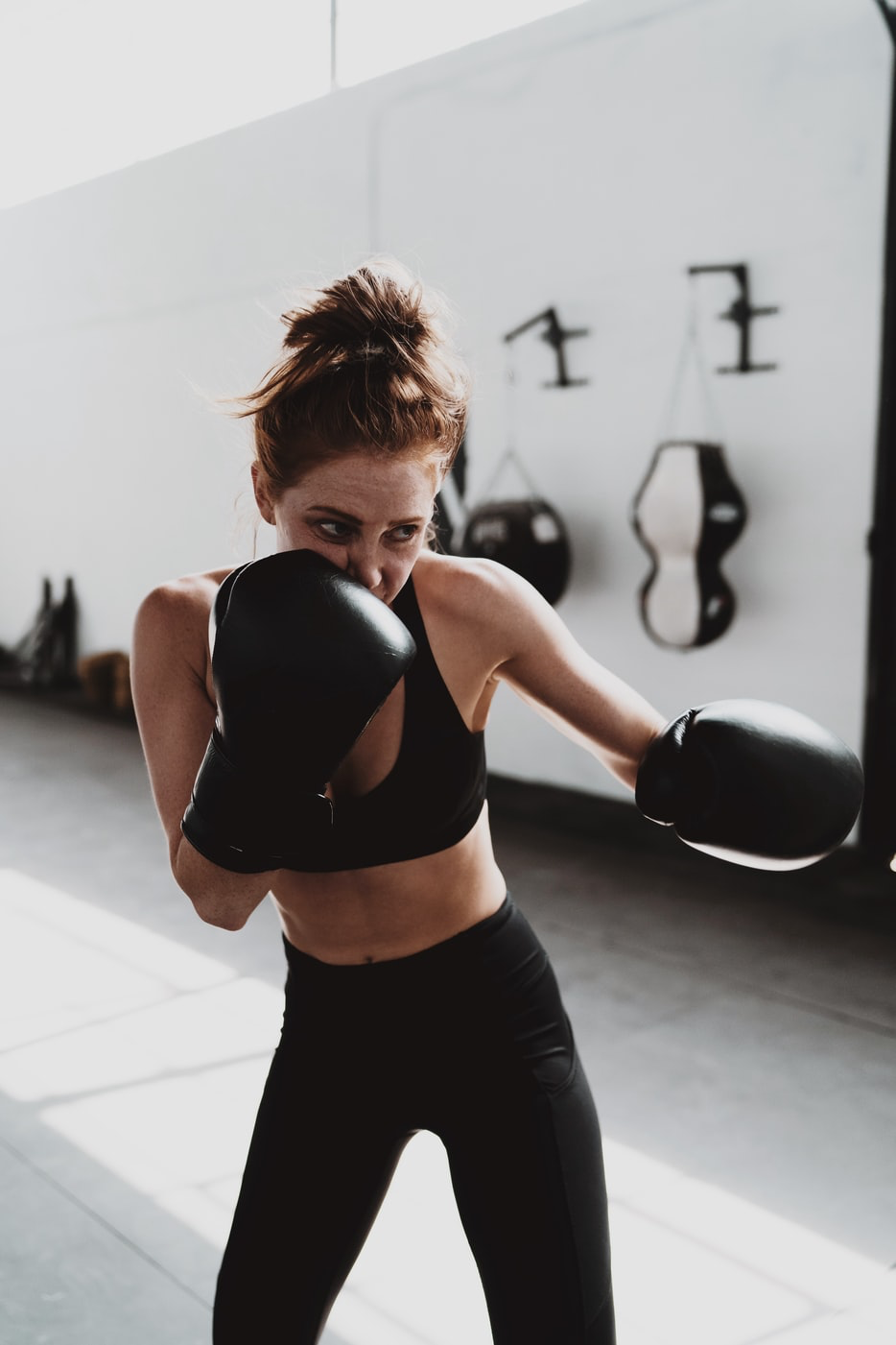 Woman practices boxing sequence at a local boxing studio.